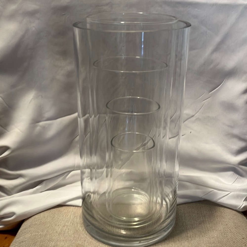 Like new.  Unique set of 5 cylinder glass vases. They stack inside largest one
